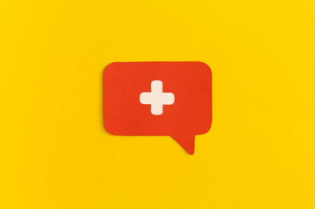 Medicine Cross On A Yellow Background. Health And Medical Treatment Concept.